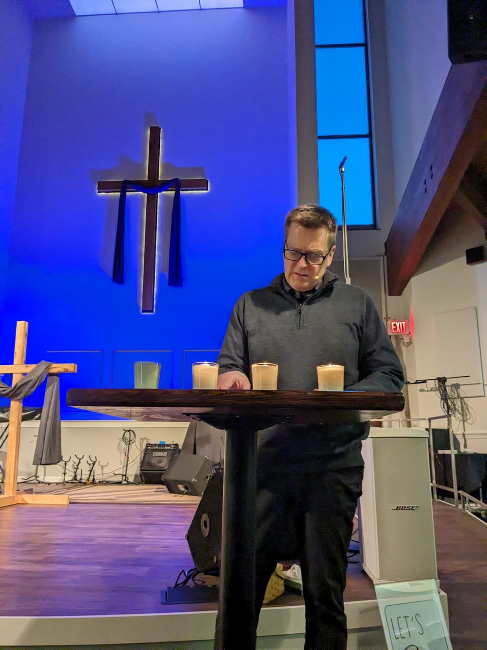 Pastor Zach preaching in front of the cross at Centerpoint