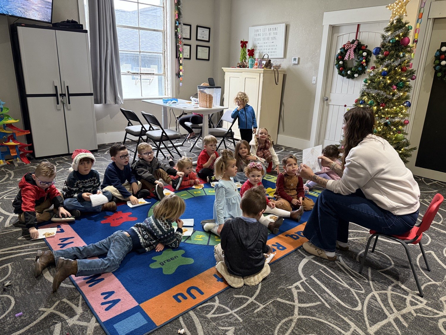A teacher reading to little ones on the alphabet rug