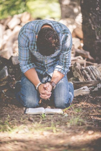 man praying on knees