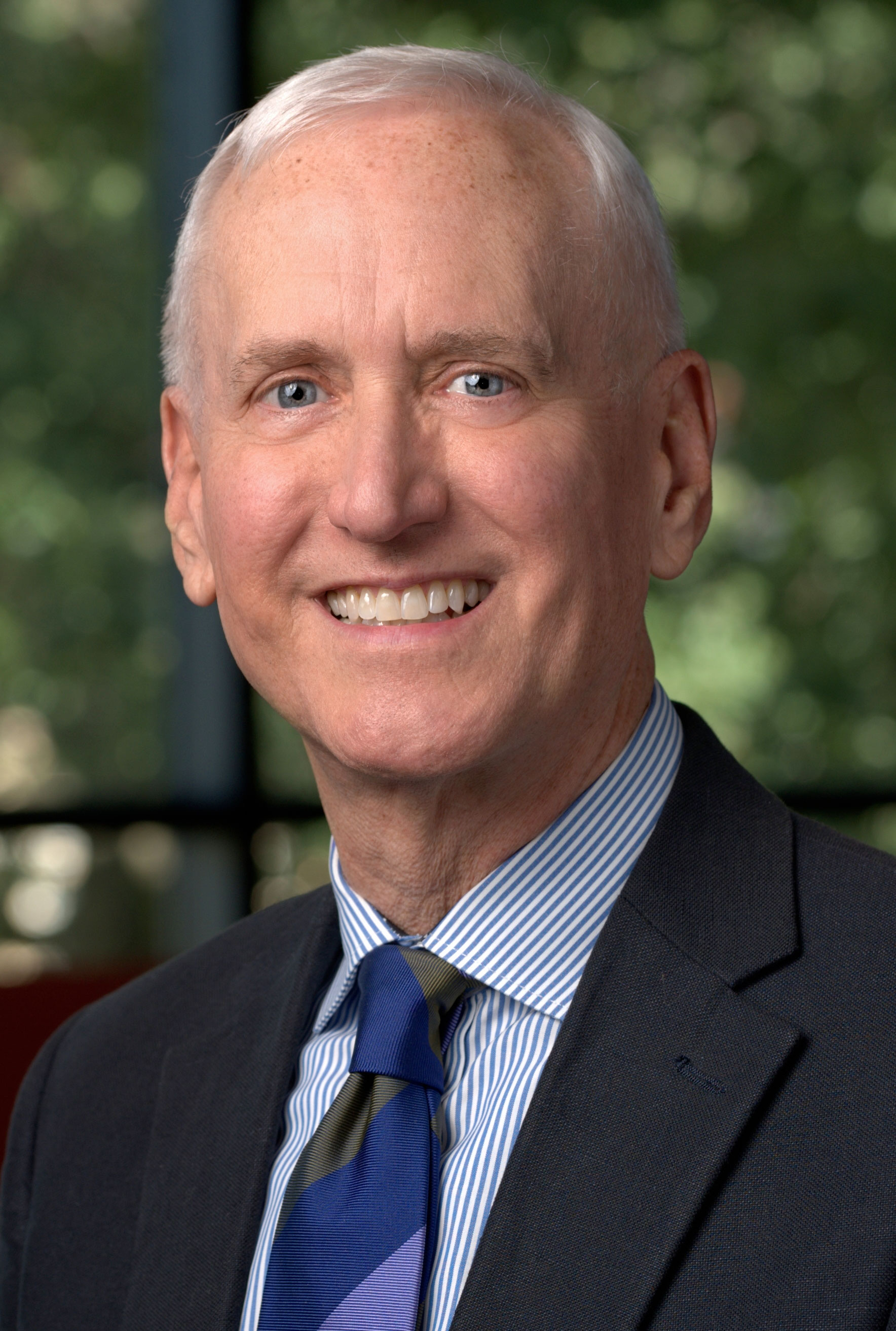 Portrait of a man in a suit smiling.