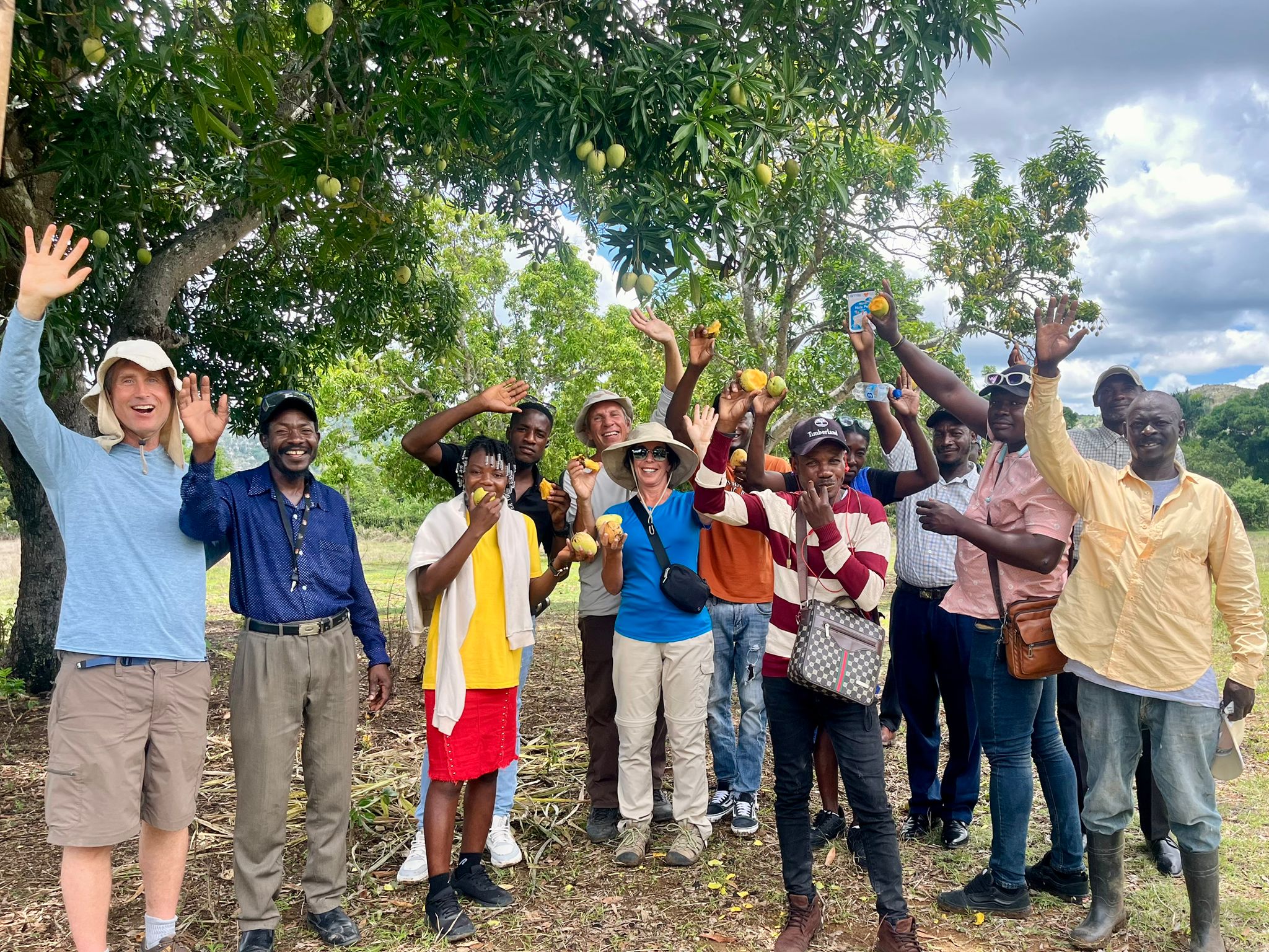 Group of missionaries and Haitians wave at the camera